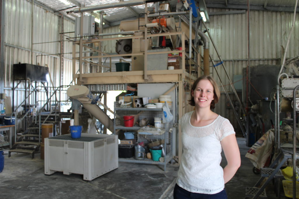 Amy in front of the feed mill where they produce the feed for the chickens in their studies. (Credit: Poultry Research Foundation, University of Sydney)
